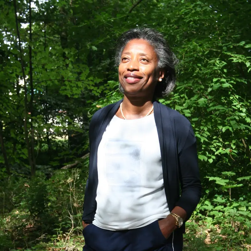 Heilpraktikerin für Psychotherapie Marie-Laure Mader im Wald, lächelnd mit Sonne im Gesicht